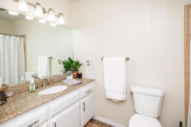 15222 Riverside Drive Apple Valley, CA 92307 - Photo 18 of 43 a bathroom with a granite countertop sink a toilet and a mirror