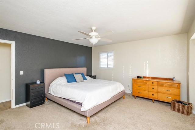 15222 Riverside Drive Apple Valley, CA 92307 - Photo 21 of 43 a bedroom with a bed and a chandelier