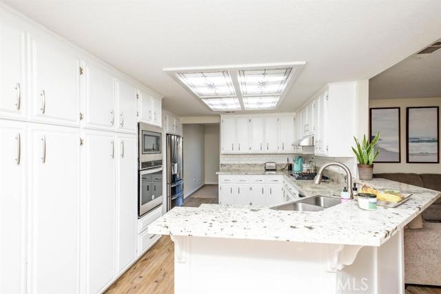 15222 Riverside Drive Apple Valley, CA 92307 - Photo 7 of 43 a kitchen with stainless steel appliances kitchen island granite countertop a sink and cabinets