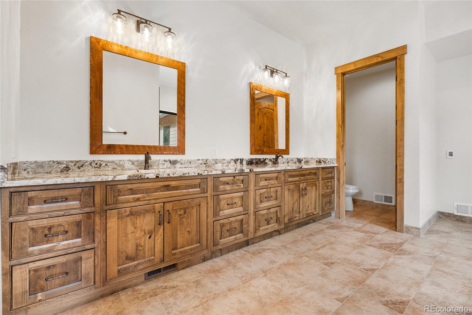 280 Double Tree Road Bailey, CO 80421 - Photo 33 of 43 a spacious bathroom with a granite countertop sink and a mirror
