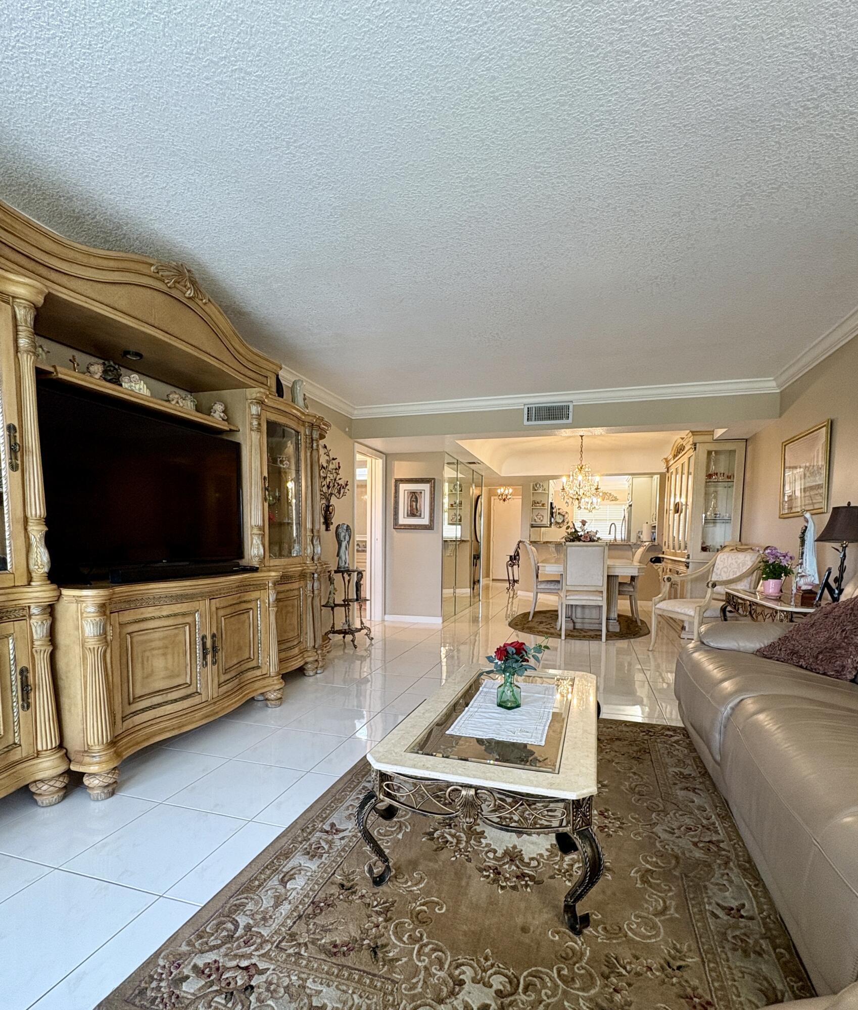 23249 Barwood Lane North, Unit 402 Boca Raton, FL 33428 - Photo 2 of 27 a living room with furniture and a flat screen tv