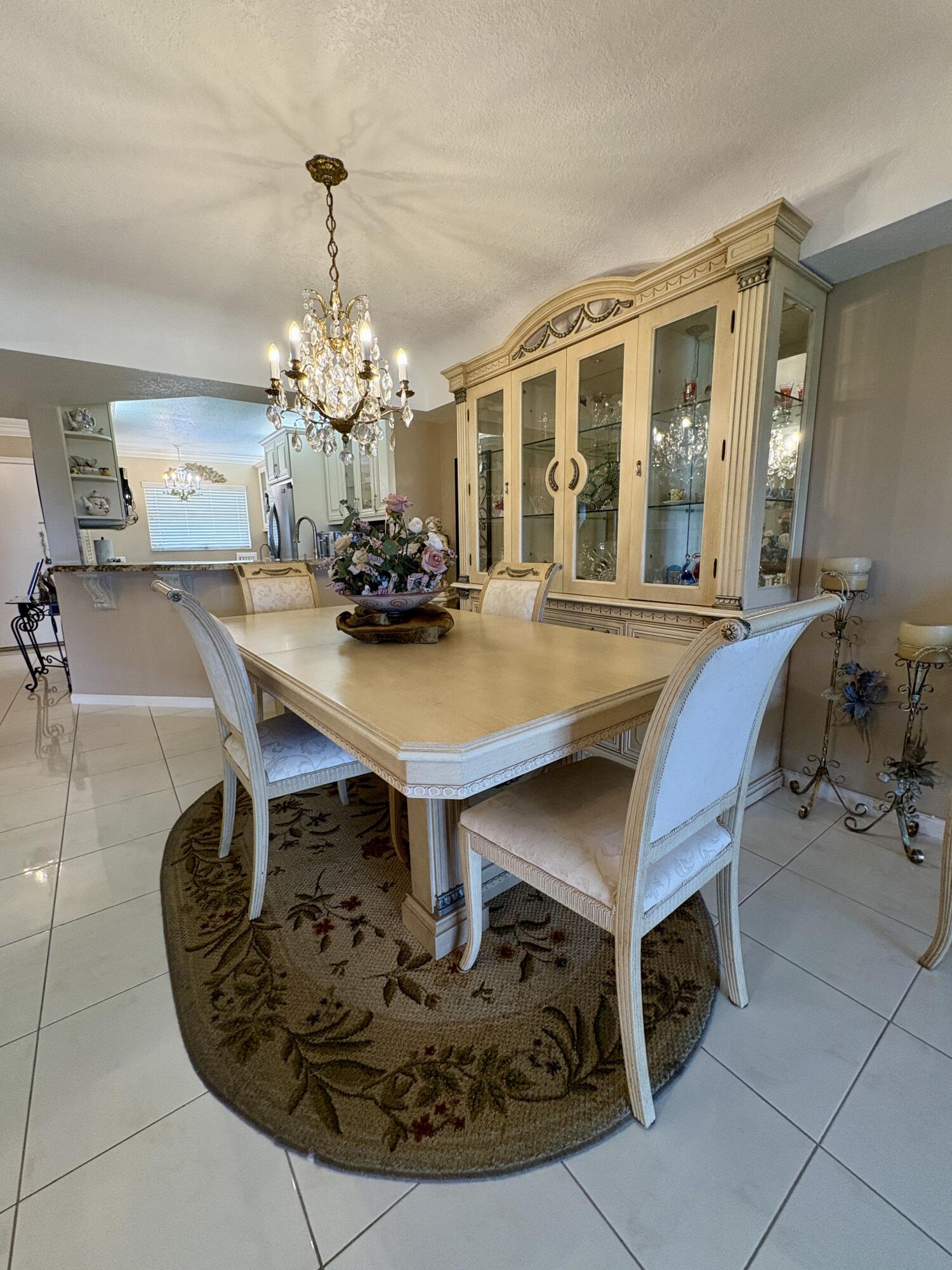 23249 Barwood Lane North, Unit 402 Boca Raton, FL 33428 - Photo 6 of 27 a view of a dining room with furniture and chandelier