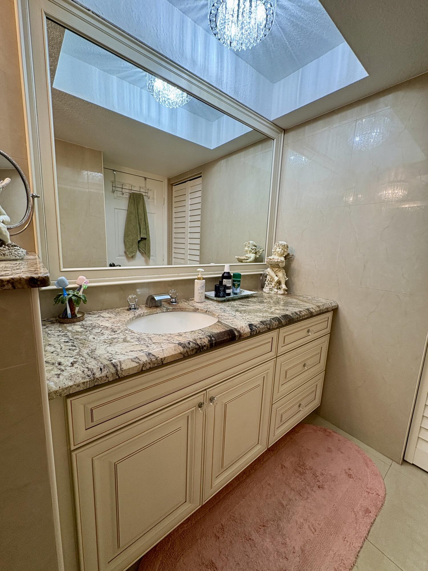 23249 Barwood Lane North, Unit 402 Boca Raton, FL 33428 - Photo 8 of 27 a bathroom with a granite countertop sink and a mirror