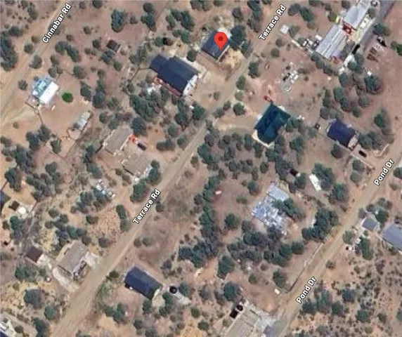 a aerial view of a house with a yard and large trees