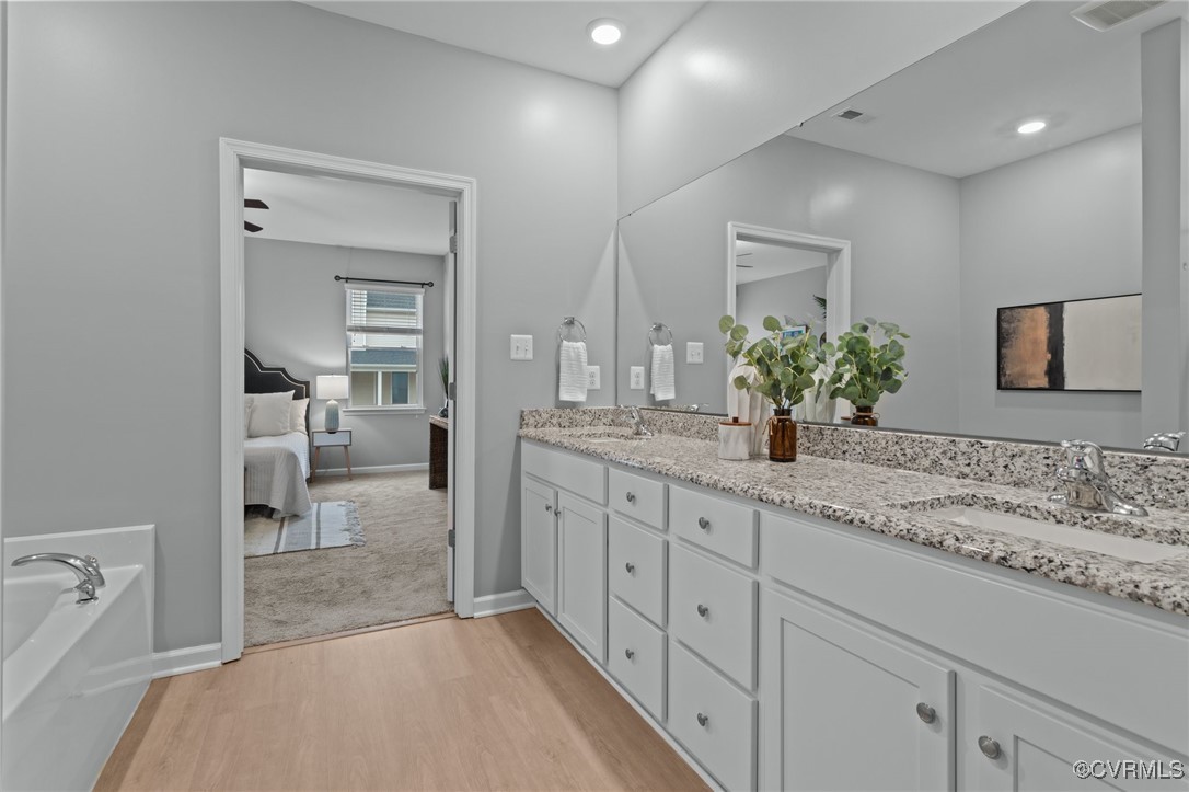 15624 Cedarville Drive Midlothian, VA 23112 - Photo 29 of 49 a spacious bathroom with a granite countertop sink a mirror and a bathtub