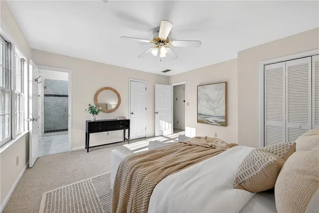 a bedroom with a bed a chandelier and mirror on the dresser