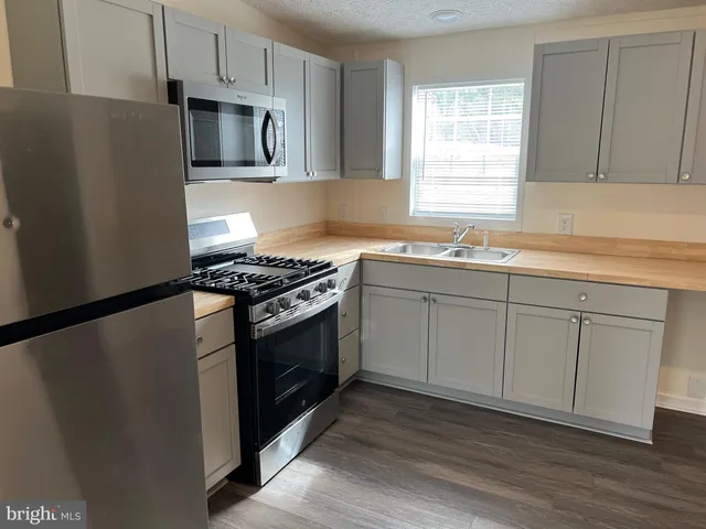 a kitchen with white cabinets stainless steel appliances and sink