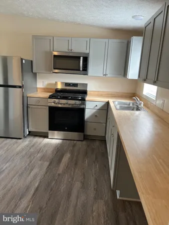 a kitchen with granite countertop a stove and a refrigerator