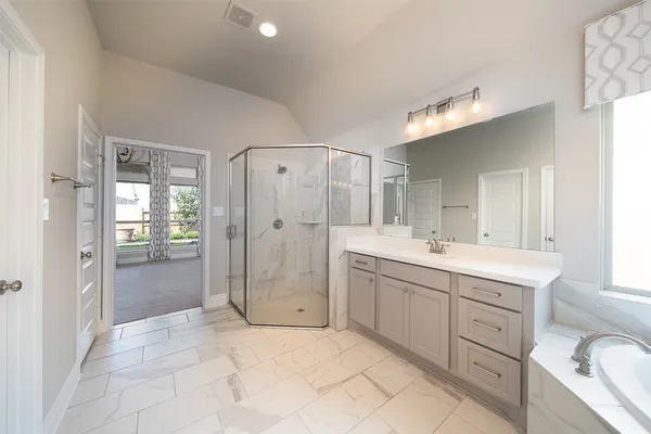 a spacious bathroom with a shower a sink and mirror