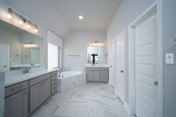 a large bathroom with a double vanity sink a mirror and a bathtub