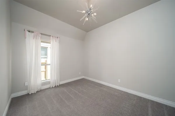 an empty room with a window and ceiling fan