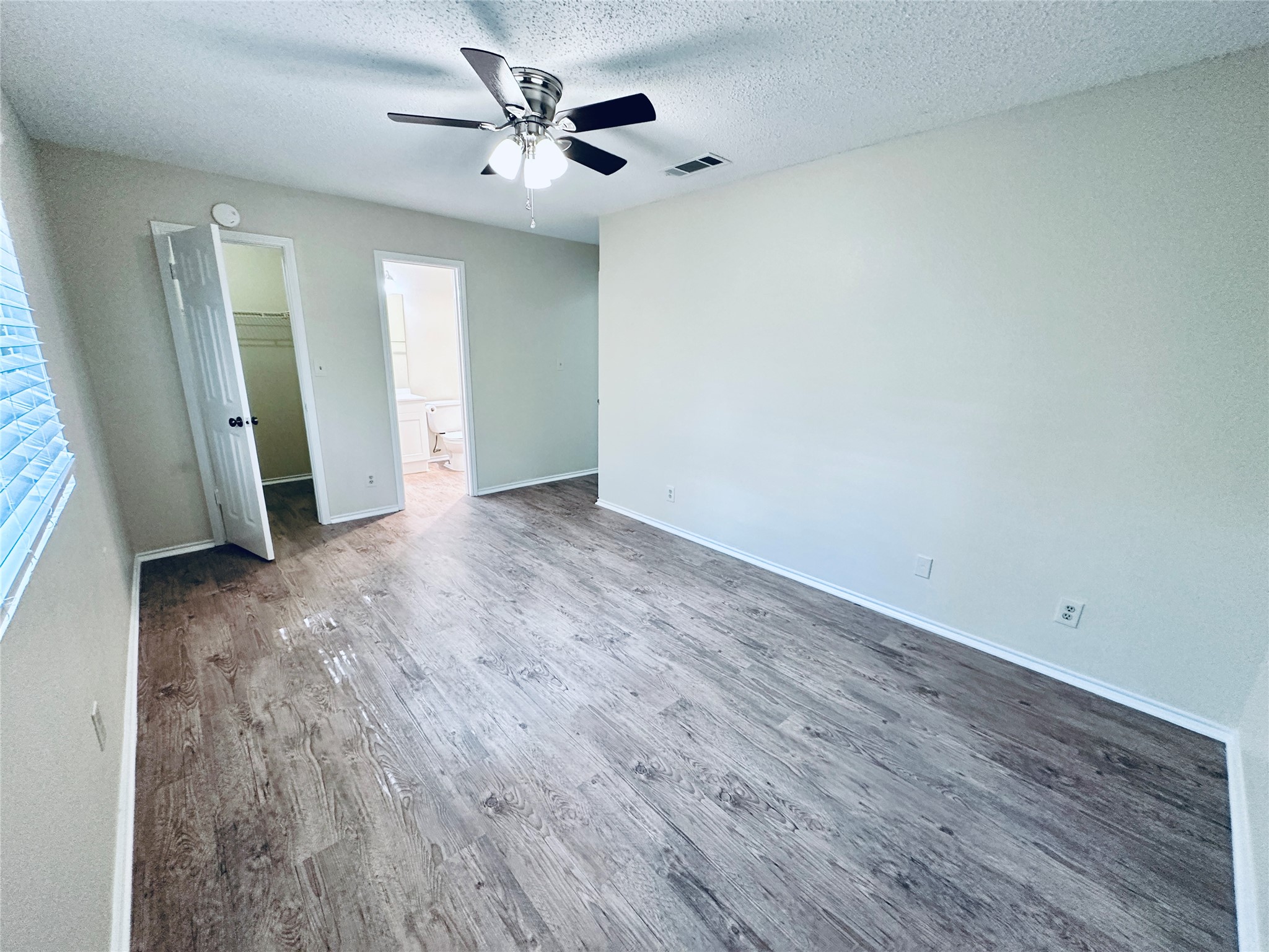 379 Fantail Loop, Unit B Austin, TX 78734 - Photo 27 of 33 Smooth wood-look flooring and tall windows create a bright and airy atmosphere.