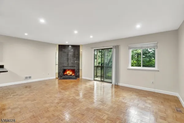 a view of an empty room with a window and fireplace