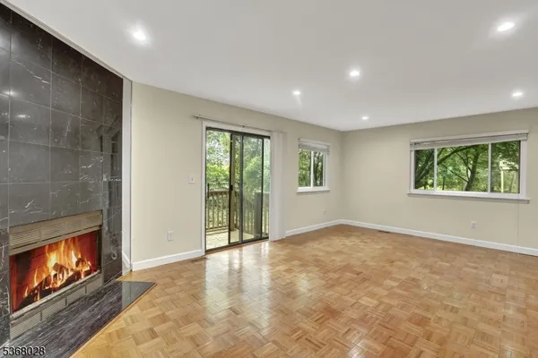an empty room with windows and fireplace