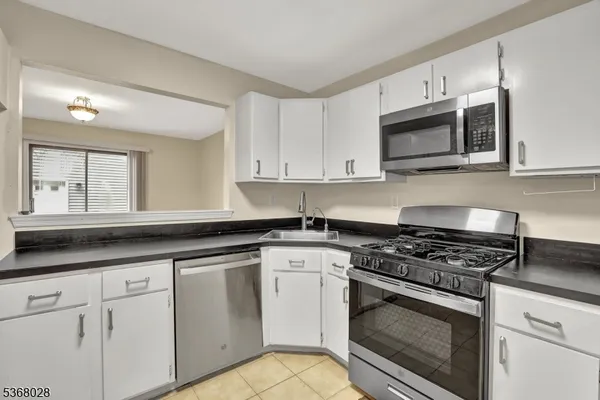 a kitchen with white cabinets and appliances