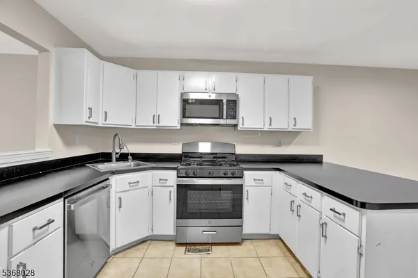 a kitchen with white cabinets and appliances