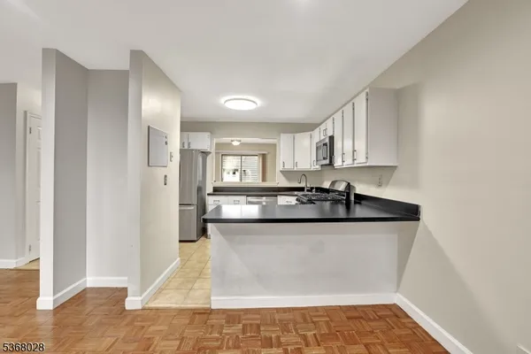 a view of a kitchen with stainless steel appliances granite countertop a sink and a stove