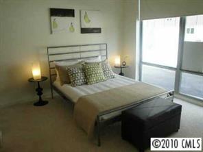 2116 McClintock Road, Unit 213 Charlotte, NC 28205 - Photo 7 of 8 a bedroom with a bed and a table