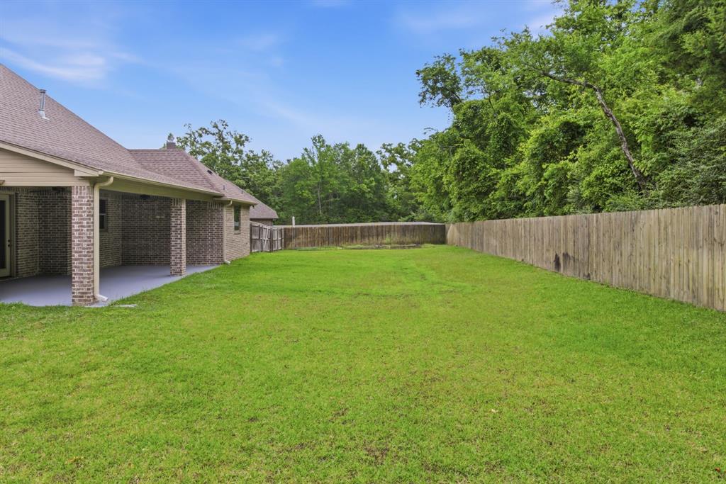 7765 Hickory Spring Lane Tyler, TX 75703 - Photo 36 of 38 Expansive green lawn with a wood privacy fence