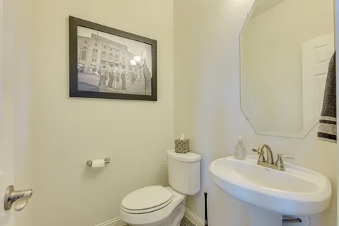 a bathroom with a toilet a sink and mirror