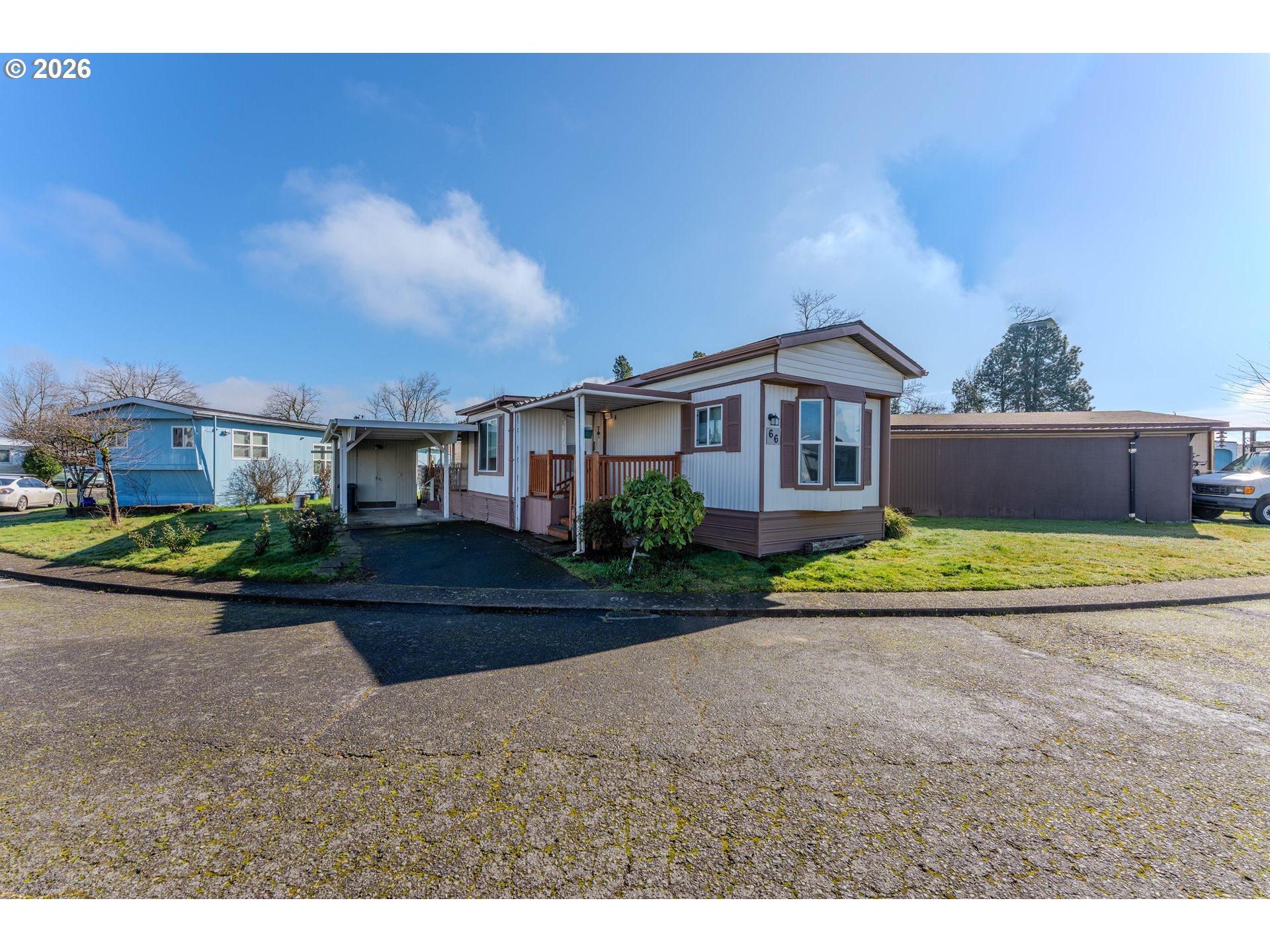 1999 Jansen Way, Unit 66 Woodburn, OR 97071 - Photo 1 of 26 a view of a big house with a big yard and large trees