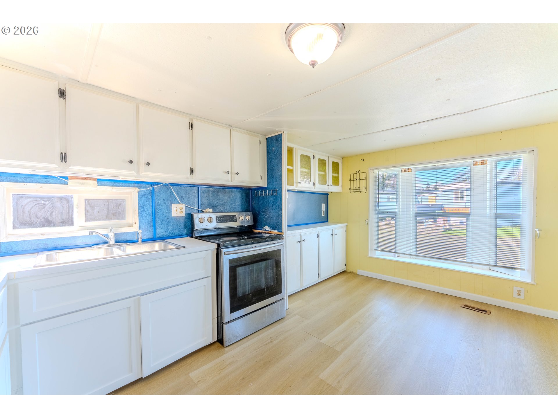 1999 Jansen Way, Unit 66 Woodburn, OR 97071 - Photo 8 of 26 a kitchen with stainless steel appliances granite countertop a stove a sink and white cabinets with wooden floor