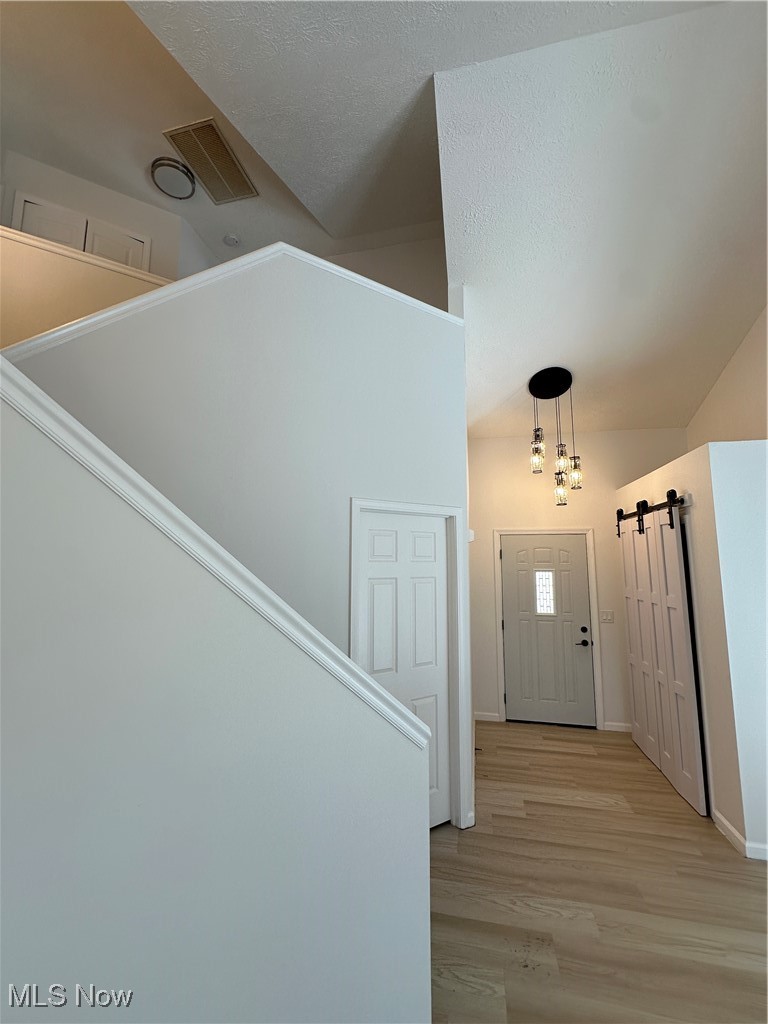 5205 Cline Road, Unit A Kent, OH 44240 - Photo 5 of 23 Entryway featuring a barn door, light wood finished floors, and a textured ceiling