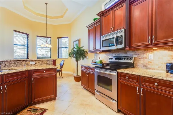 a kitchen with stainless steel appliances granite countertop a stove a sink and a microwave