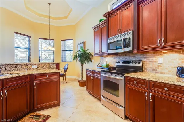 a kitchen with stainless steel appliances granite countertop a stove a sink and a microwave