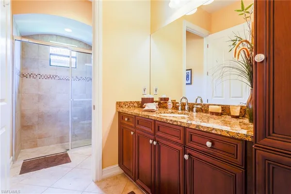 a bathroom with a granite countertop sink a mirror and a shower