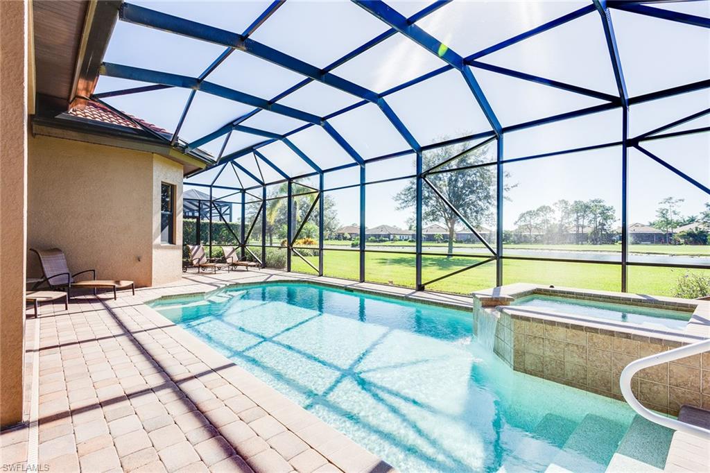 7747 Cottesmore Drive Naples, FL 34113 - Photo 25 of 32 a swimming pool with large glass windows and painted walls