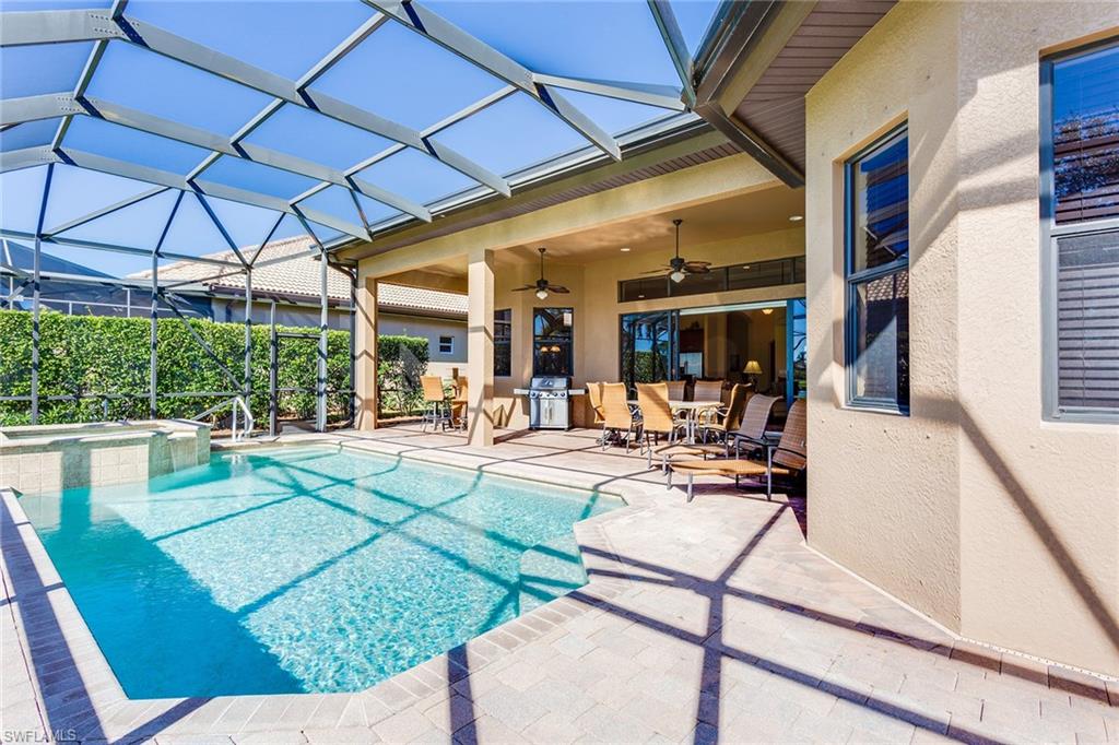 7747 Cottesmore Drive Naples, FL 34113 - Photo 27 of 32 a view of a patio with a table and chairs under an umbrella