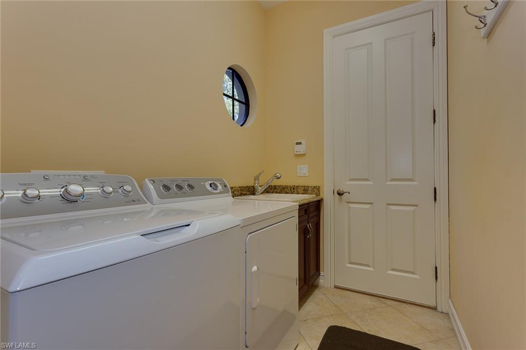 7747 Cottesmore Drive Naples, FL 34113 - Photo 30 of 32 a bathroom with a sink and a mirror