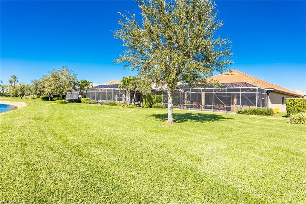 7747 Cottesmore Drive Naples, FL 34113 - Photo 32 of 32 a front view of a house with a garden