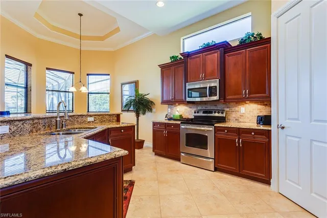 a kitchen with stainless steel appliances granite countertop a sink a stove and a microwave