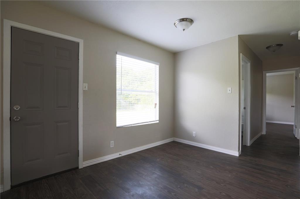 1410 Ransom Street Pflugerville, TX 78660 - Photo 3 of 22 a view of an empty room with wooden floor and a window