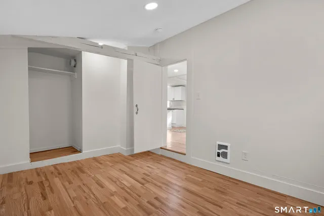 a view of an empty room with wooden floor