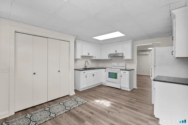 a kitchen with granite countertop a refrigerator and a stove top oven