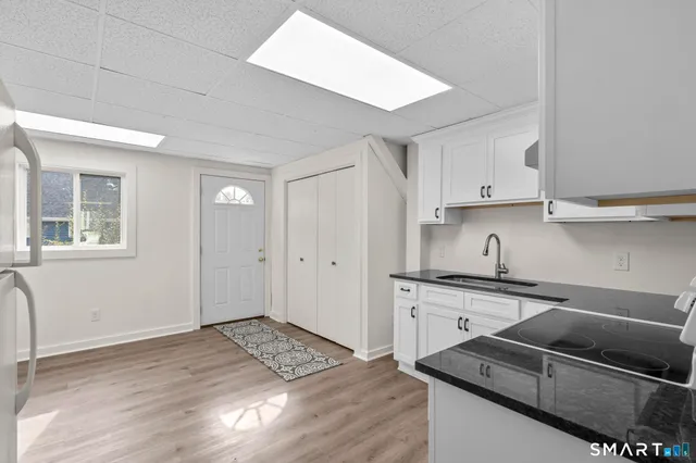 a kitchen with granite countertop a sink stove and cabinets