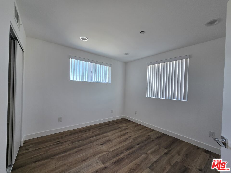 449 West 74th Street Los Angeles, CA 90003 - Photo 7 of 28 a view of an empty room with wooden floor and a window