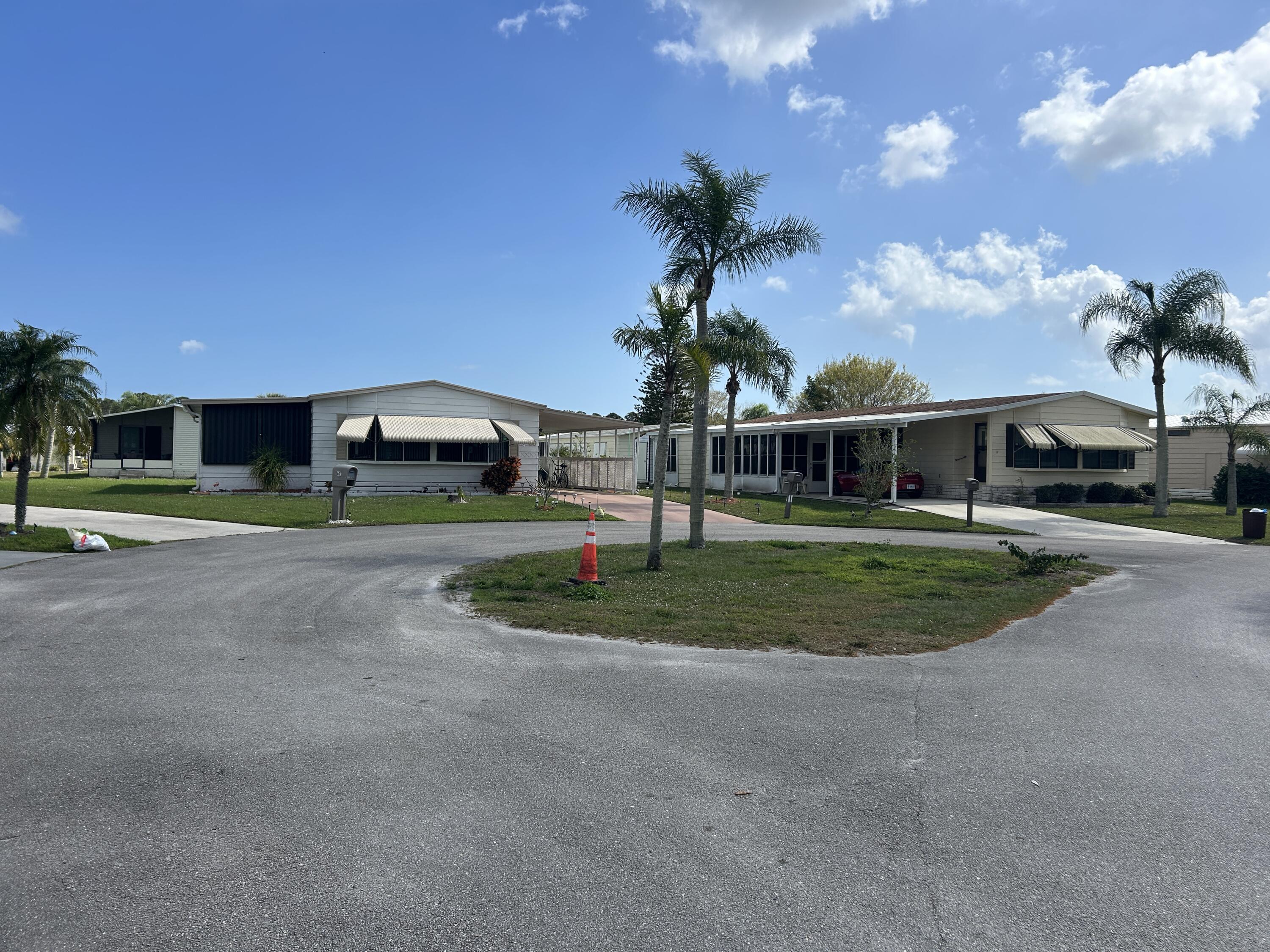 63 Ipanema Way Fort Pierce, FL 34951 - Photo 16 of 49 a front view of a house with a yard and palm tree