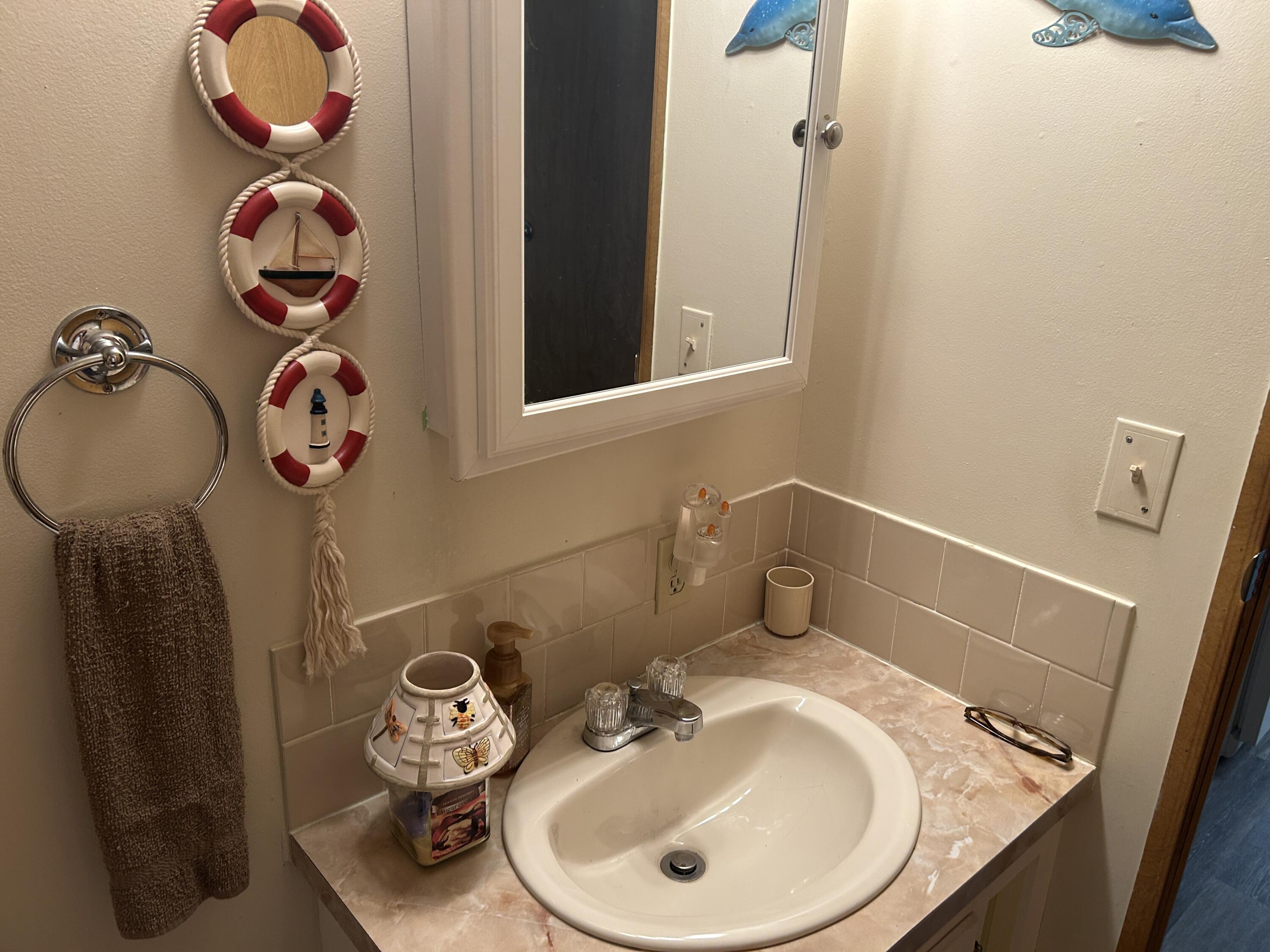 63 Ipanema Way Fort Pierce, FL 34951 - Photo 35 of 49 a bathroom with a sink mirror and toilet
