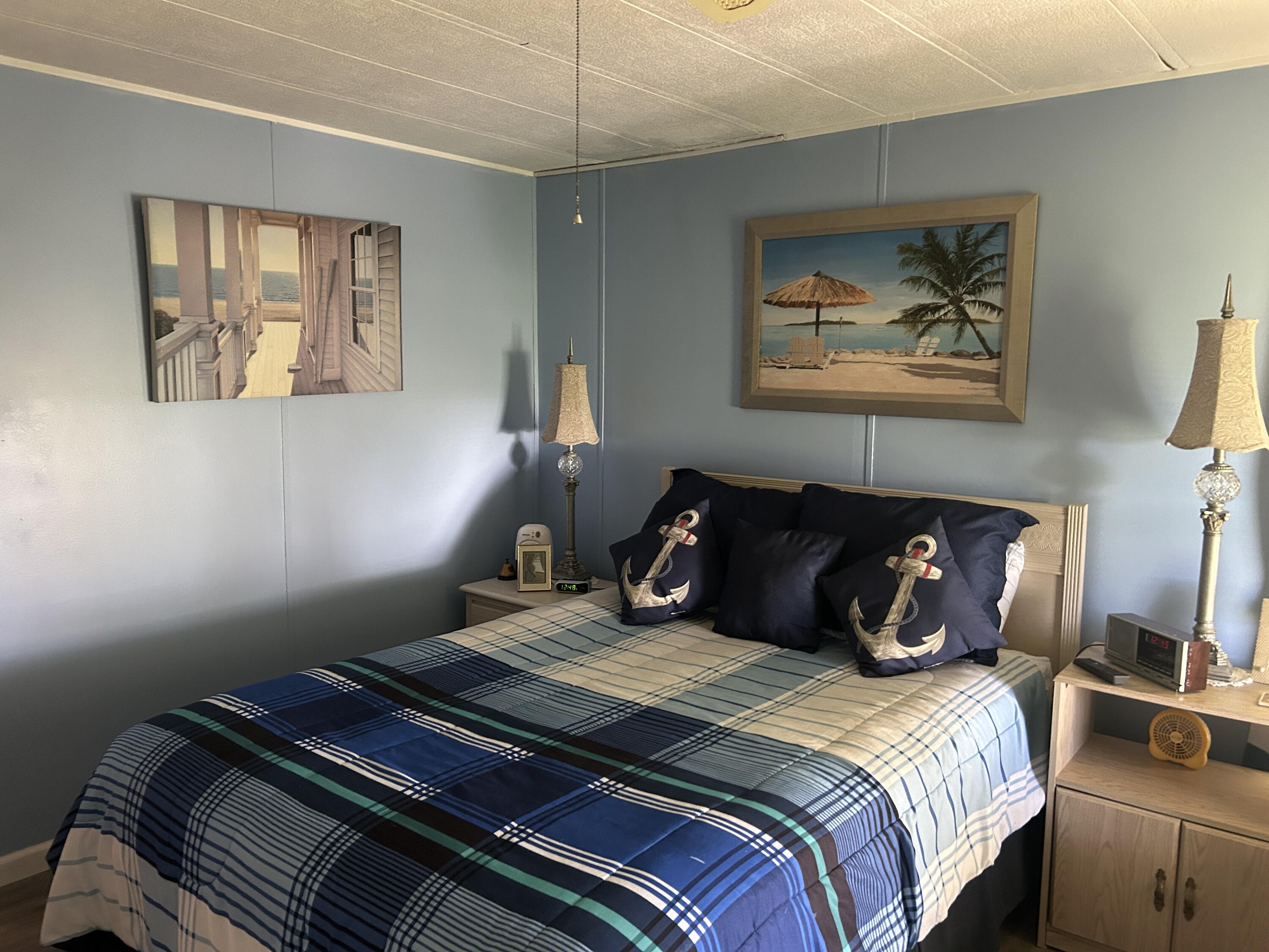 63 Ipanema Way Fort Pierce, FL 34951 - Photo 41 of 49 a bedroom with bed and painting on the wall
