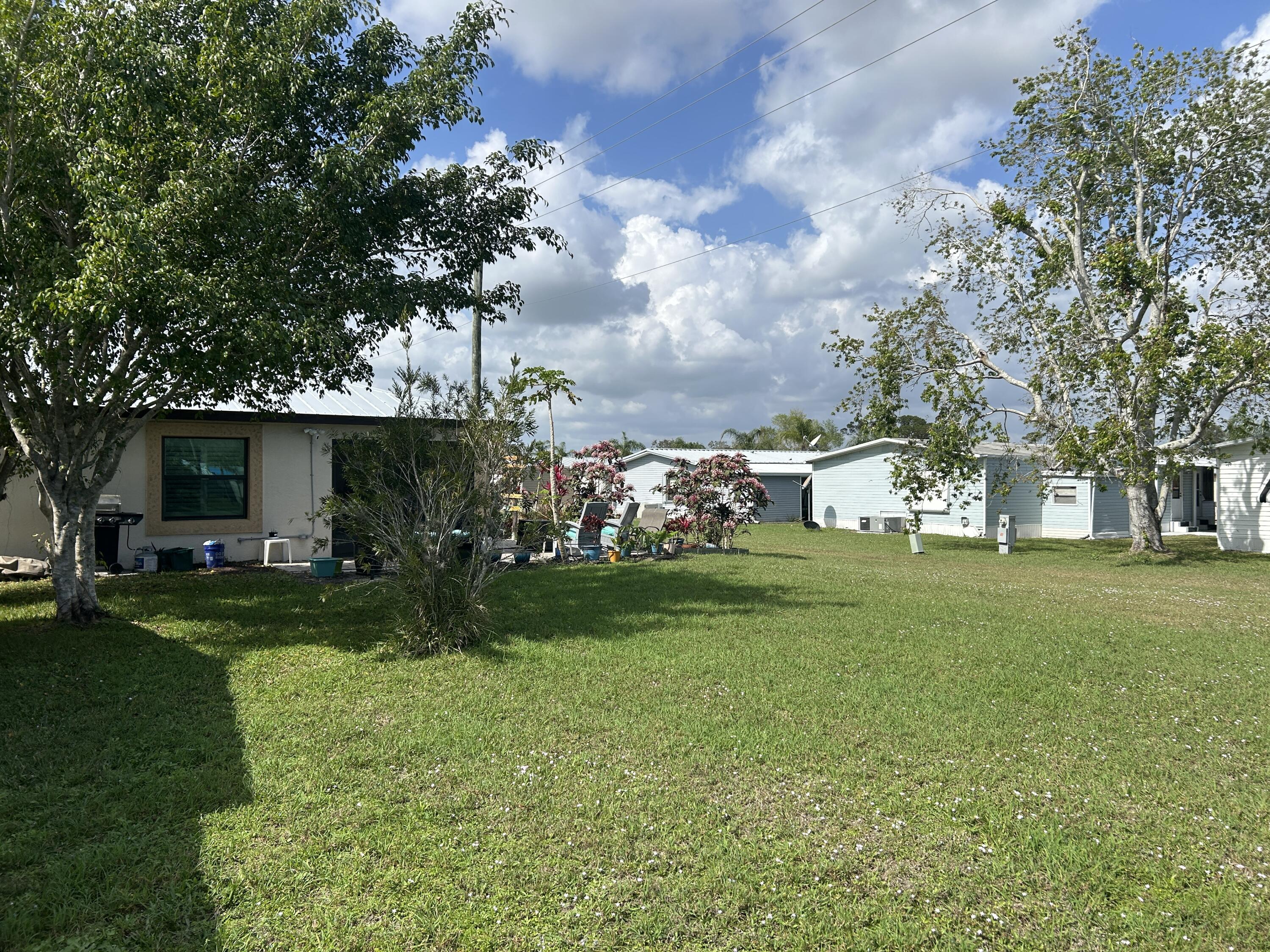 63 Ipanema Way Fort Pierce, FL 34951 - Photo 7 of 49 a view of a house with a big yard plants and large trees
