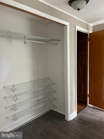 a view of walk in closet with empty racks