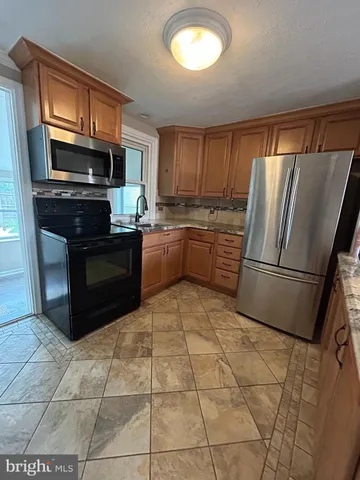 a kitchen with stainless steel appliances granite countertop a refrigerator sink and stove