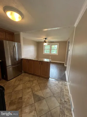 a view of a refrigerator in kitchen and a windows