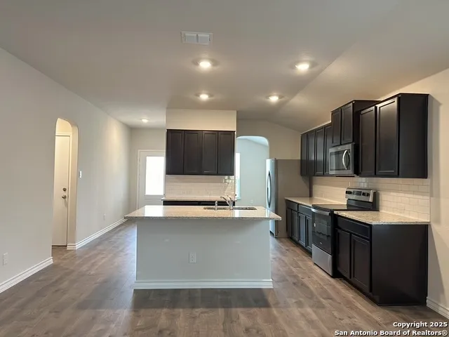 a view of kitchen with stainless steel appliances kitchen island sink stove and refrigerator