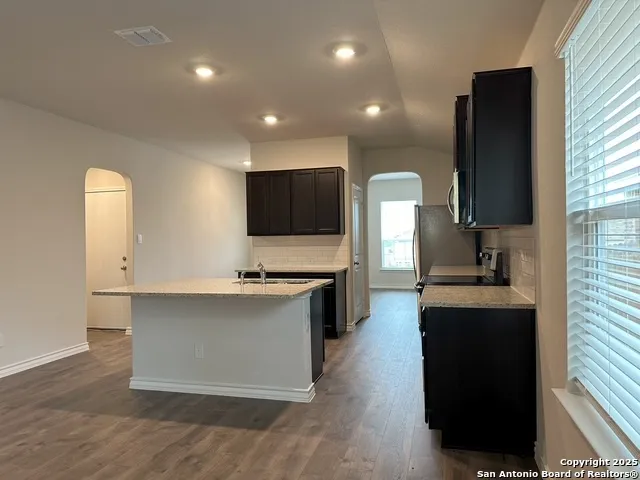 a kitchen with stainless steel appliances a sink stove and refrigerator