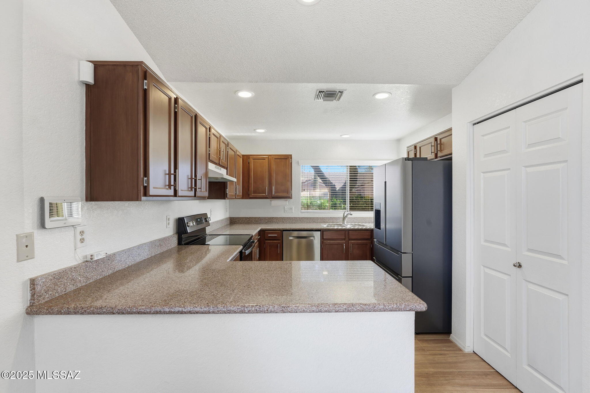 3592 West Sky Ridge Loop Tucson, AZ 85742 - Photo 9 of 41 a kitchen with stainless steel appliances granite countertop a sink a refrigerator and a granite counter tops